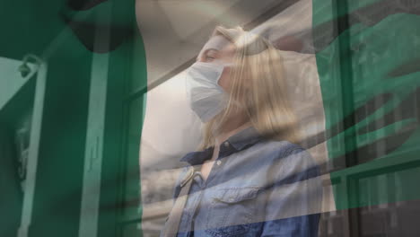 animación de la bandera de nigeria ondeando sobre una mujer caucásica con máscara facial en la calle de la ciudad