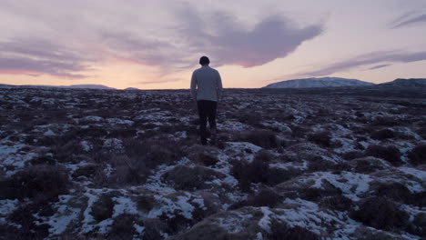 lonely man walking in vast scandinavian landscape slow motion