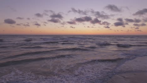 Las-Olas-Del-Mar-Enjuagan-La-Playa-Junto-Al-Mar-Al-Atardecer