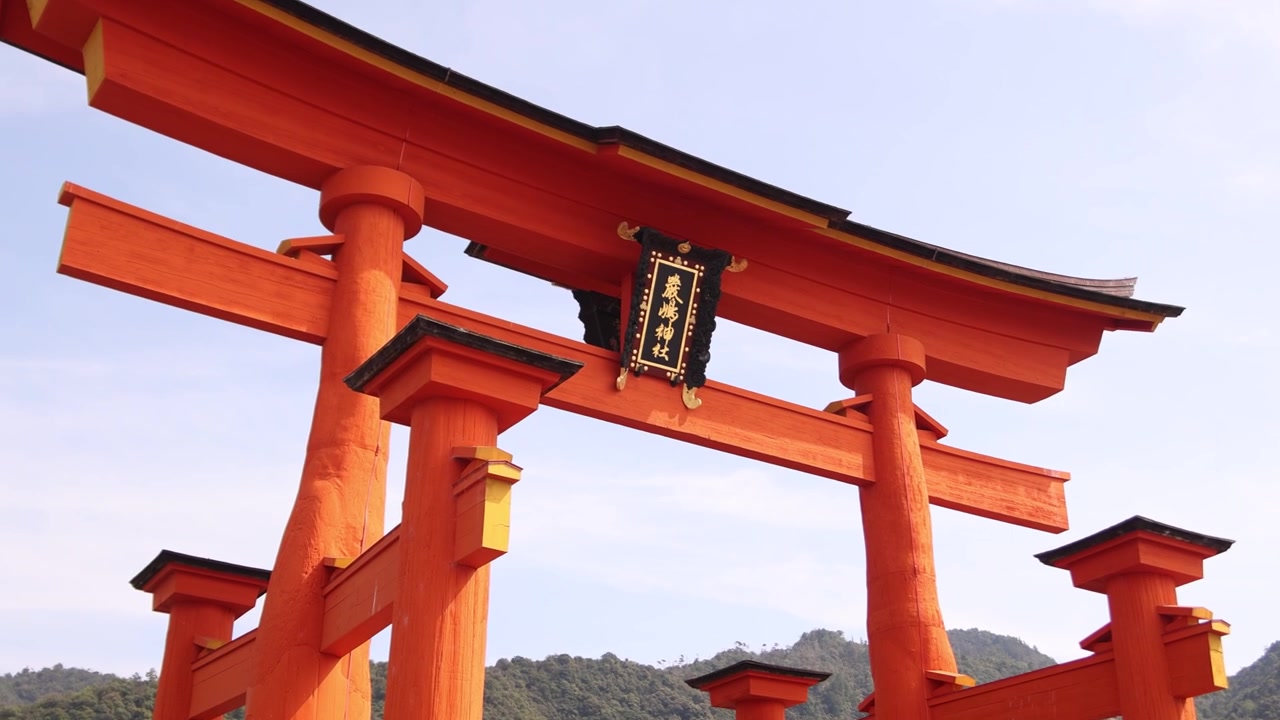 Close-up view of the vermilion wooden pillars of the grand Itsukushima Shrine torii gate during the Kangen Sai Festival on Miyajima Island, Japan