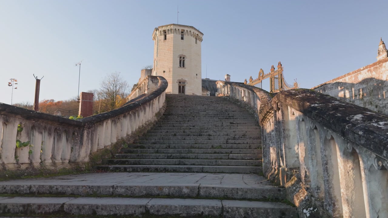 Scale del castello conducono a una maestosa torre sotto un cielo blu a Saint-Aignan, Francia.