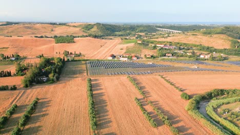 Golden fields and solar panels coexist harmoniously in the tuscan countryside, showcasing italy's commitment to sustainable energy solutions