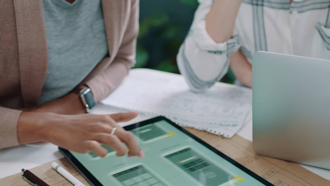 Two Women Collaborating on App Design Using a Digital Tablet