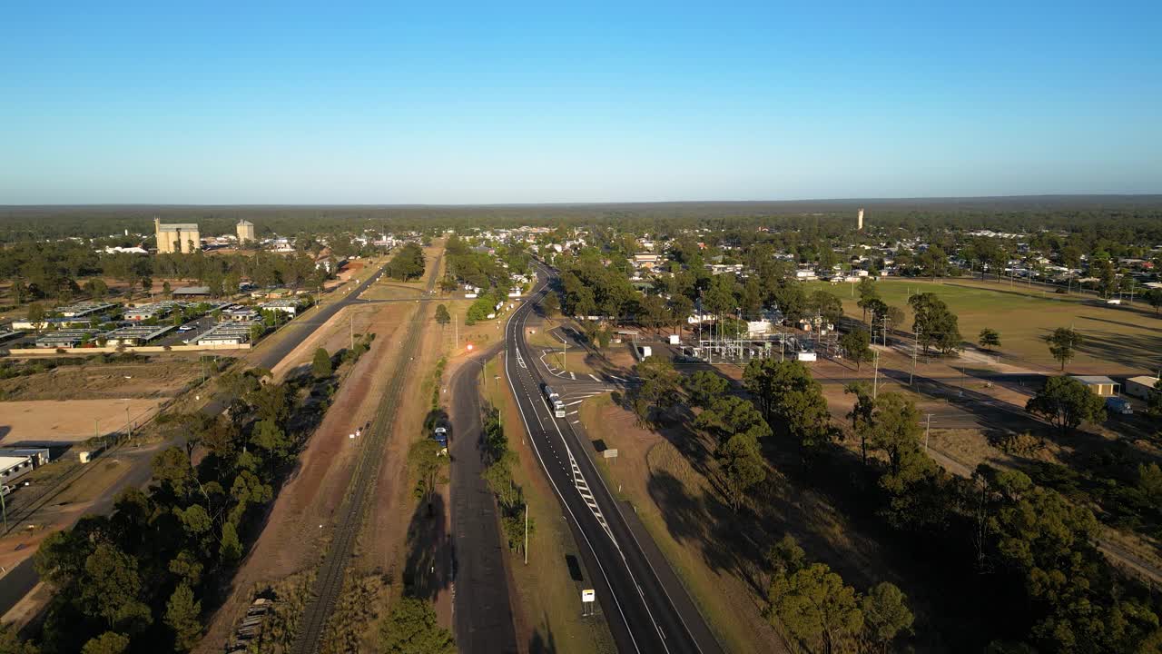 Vertical rise aerial views over the Warrego Highway, sporting fields, residential housing and the main street of Miles Queensland.