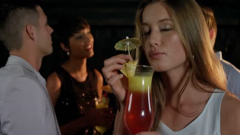 hermosa mujer joven teniendo un vaso de cóctel en el bar