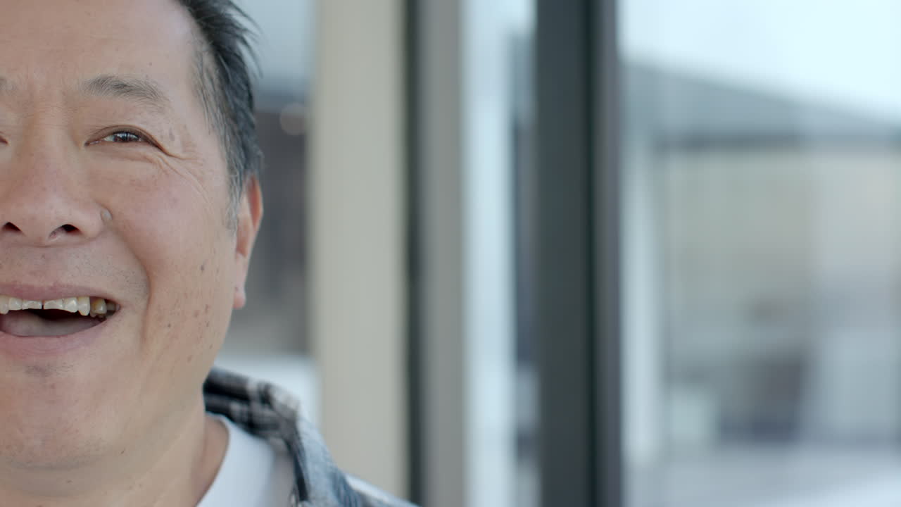 Enjoying vacation indoors, smiling senior man in close-up portrait, copy space