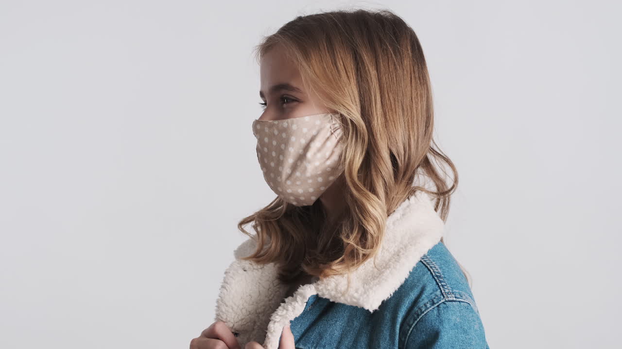 행복한 십대 백인 소녀가 얼굴 마스크를 쓰고 있습니다.