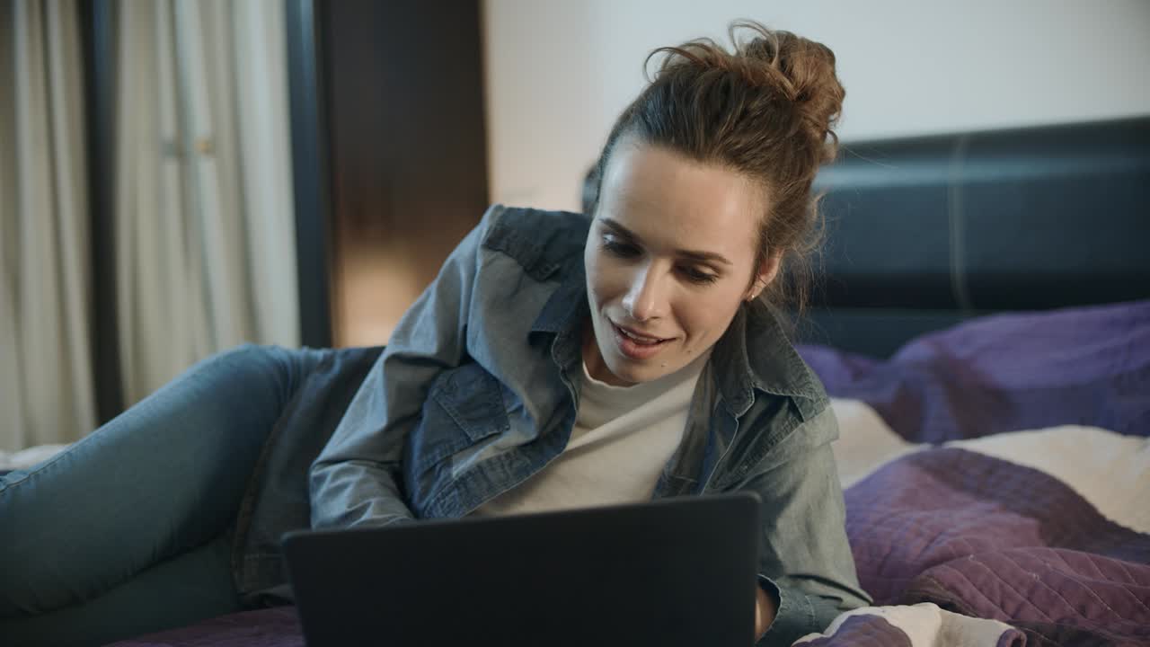 mujer feliz mirando la computadora portátil por la noche. mujer viendo video en línea