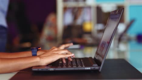 Close-up-shot-of-female-hands-typing-on-a-notebook-keyboard-with-blurred-background