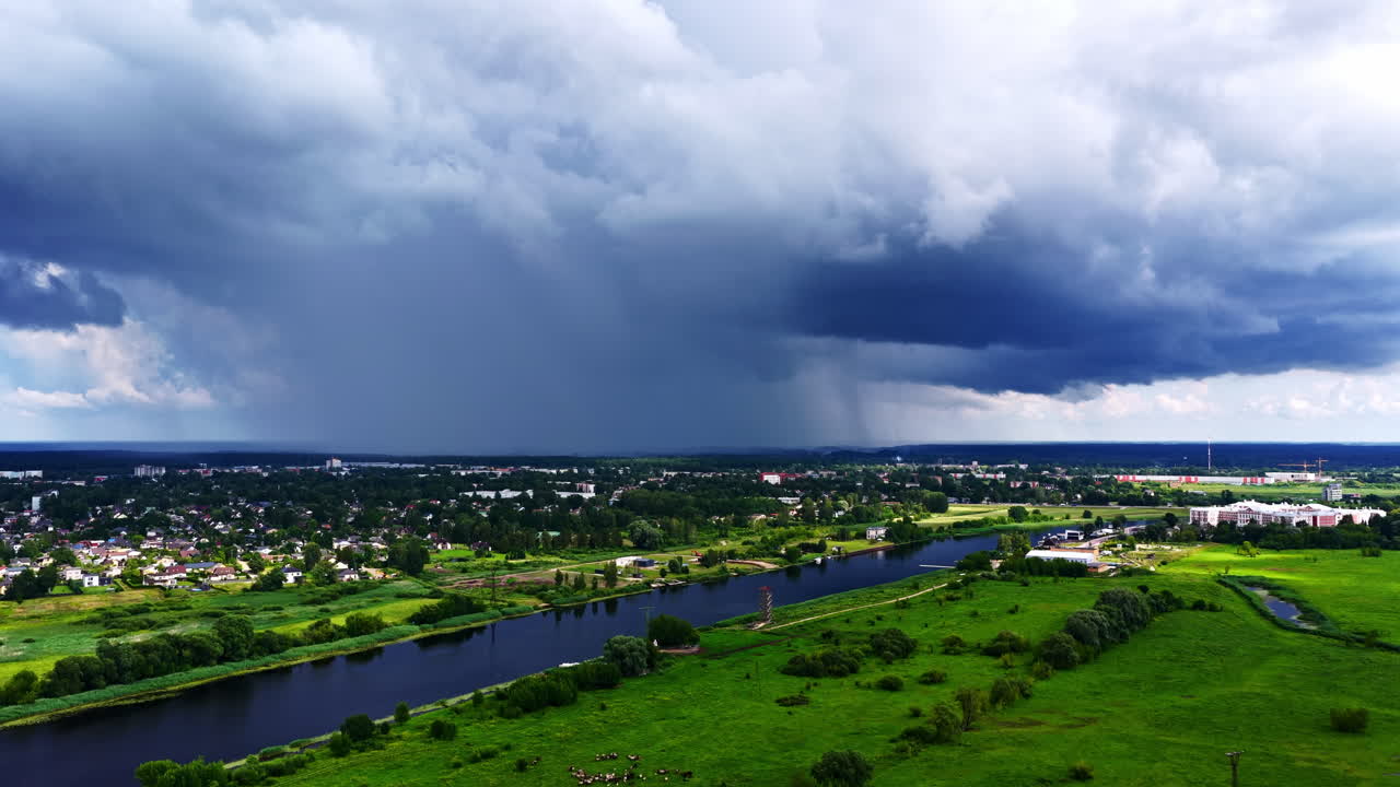 Storm approaches from horizon over farmland with dramatic clouds filling the sky, drone descends to landscape