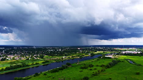 storm approaches from horizon over farmland with dramatic clouds filling the sky, drone descends to landscape