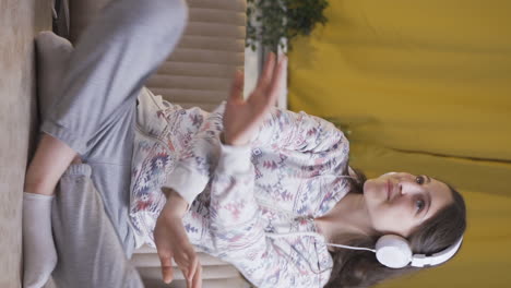 Vertical-video-of-Young-woman-dancing-at-night-while-listening-to-music-at-home.