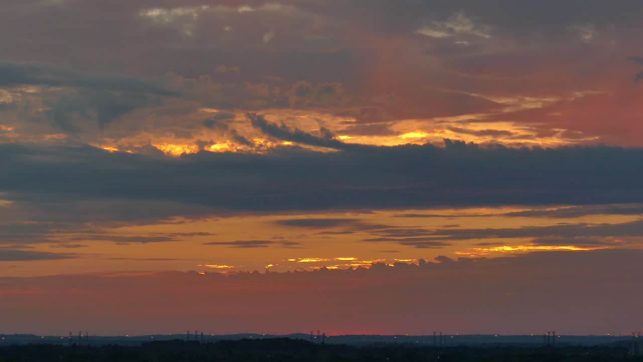 Scenic time lapse view of beautiful golden sunset with pink and blue clouds