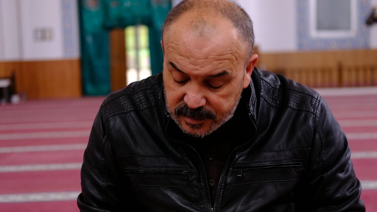 el hombre mayor lee el corán en la mezquita