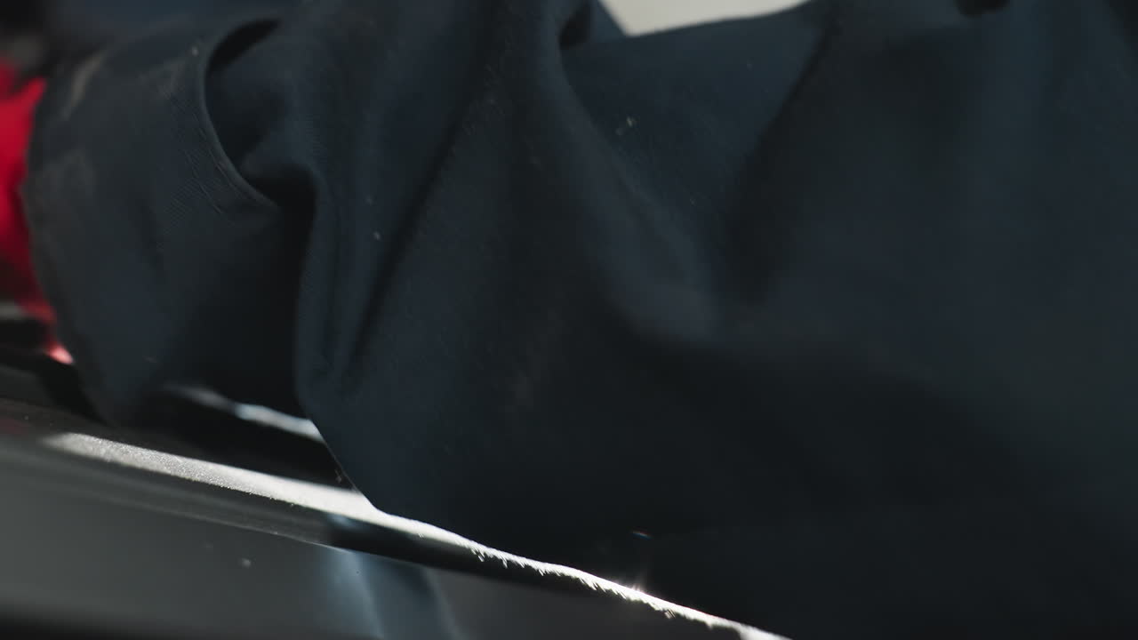 крупный план рабочей руки в красных перчатках, хватающей за ключ во время работы над механическим компонентом, отражение света на руке добавляет драматический эффект