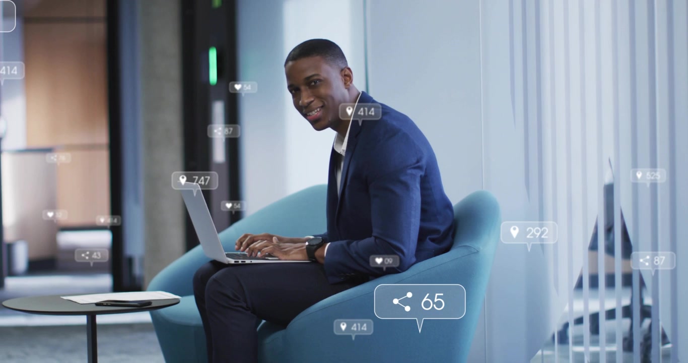 Marketing manager typing on laptop in lounge, causing floating like counters, monitoring engagement