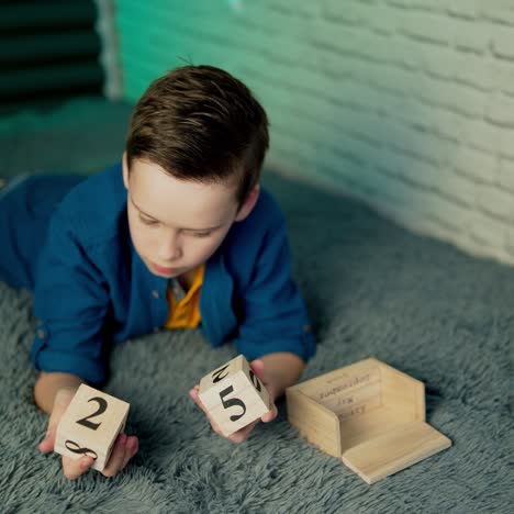 boy play with wooden block calendar.