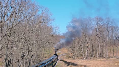 aerial view of ebt's narrow gauge restored antique steam passenger train passing with steam and smoke on a clear sunny day