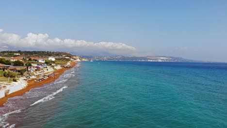 blue seascape and red sand shore of megas lakkos beach in greece - aerial drone shot