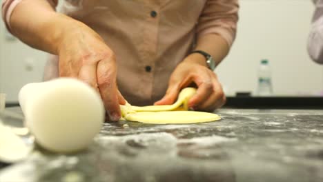 Una-Mujer-Ocupada-En-La-Cocina-Corta-El-Glaseado-De-Fondant-Con-Un-Tazón-De-Vidrio