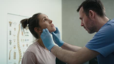 Caucasian-male-model-examining-thyroid-gland-of-young-female-caucasian-patient