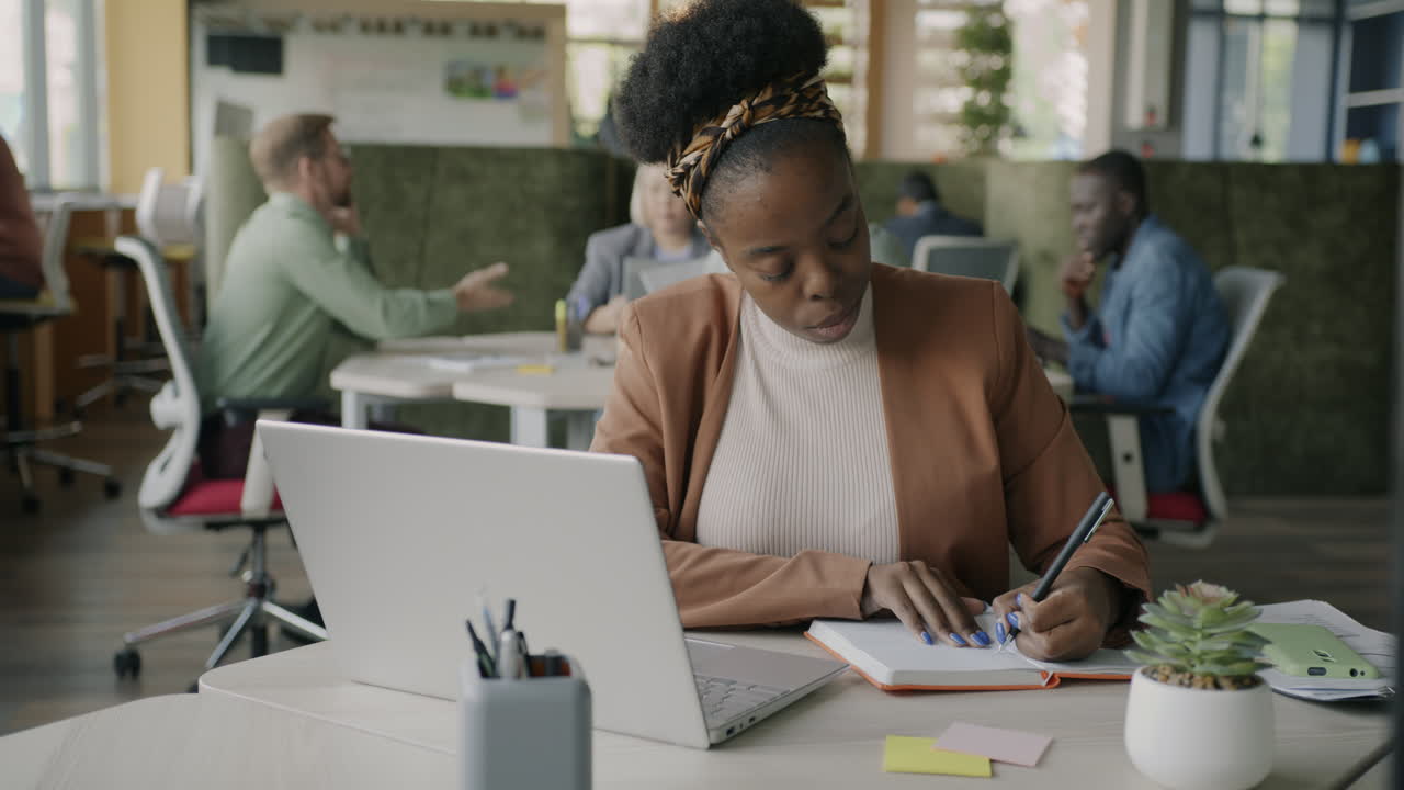 Woman Taking Notes in a Modern Office