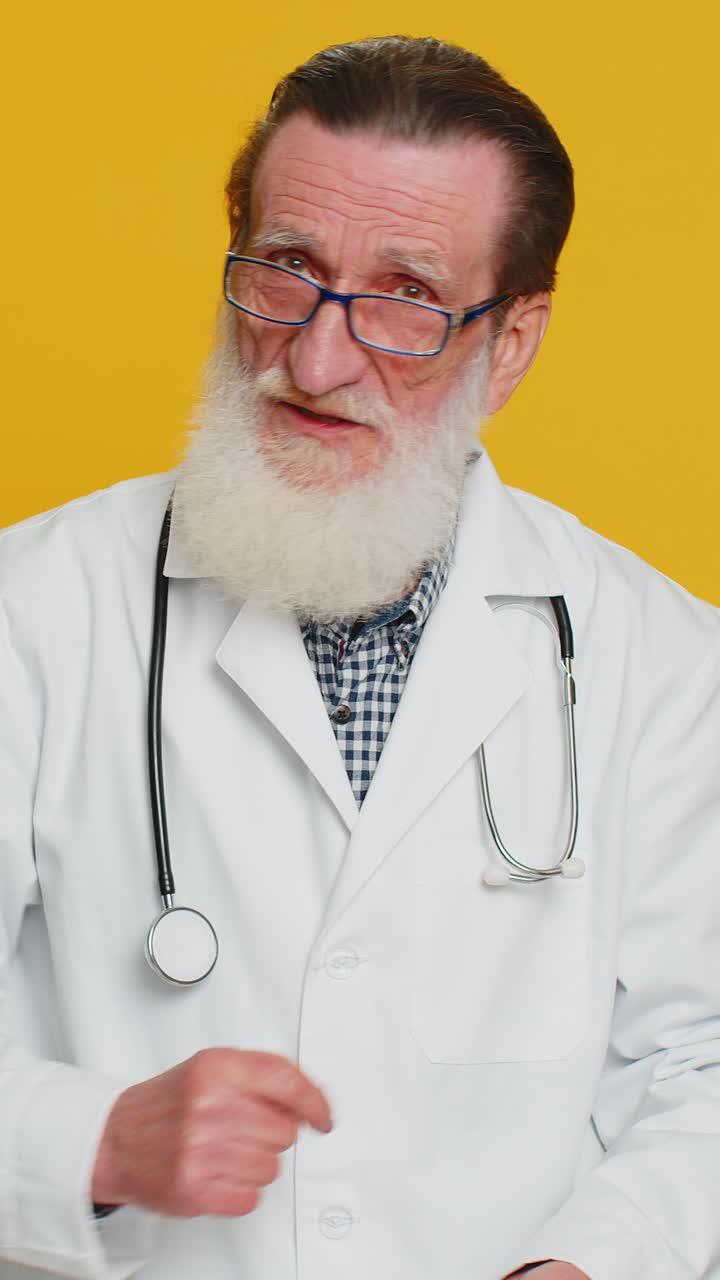 Senior doctor man shakes finger and saying no be careful avoid danger mistake disapproval sign