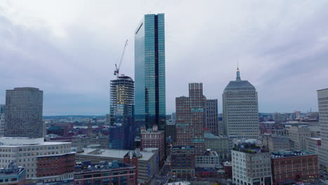 Tall-modern-glossy-glass-skyscraper-reflecting-surrounding-construction-site.-High-rise-office-buildings-at-dusk.-Boston,-USA