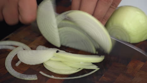 chopping onions, fast cutting onions on wooden cutting board, chef cutting onions julienne style