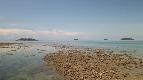 4k aerial drone footage dolly shot low flying over water and rocks in thailand