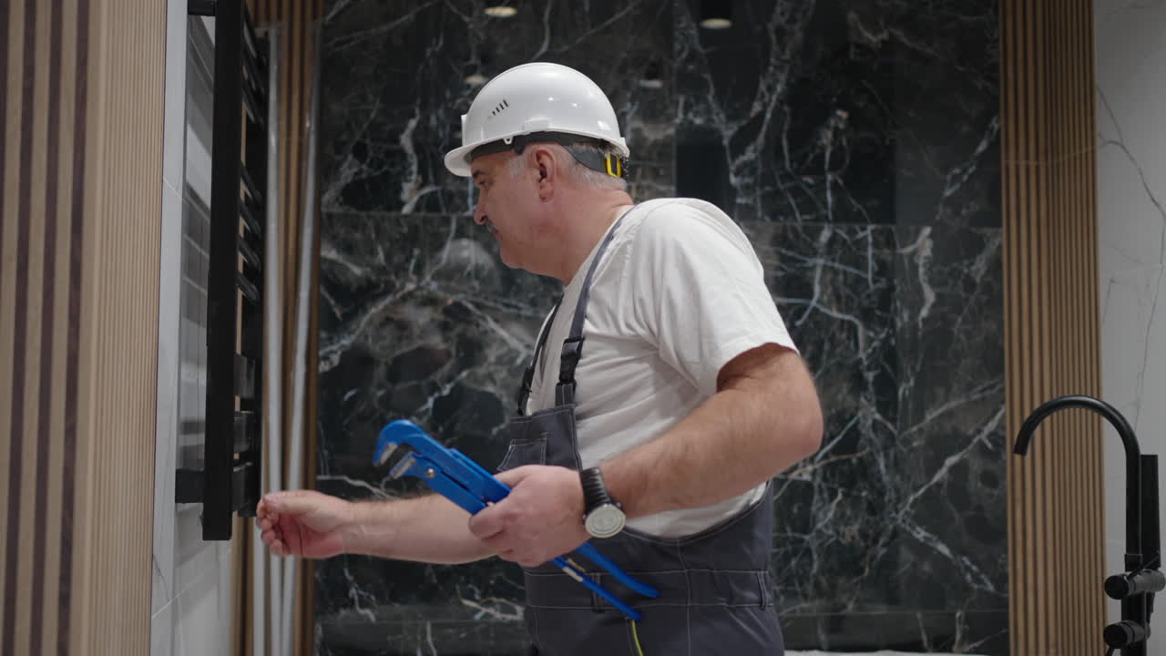Heated towel rail installed by a plumber is switched on and checked in the bathroom