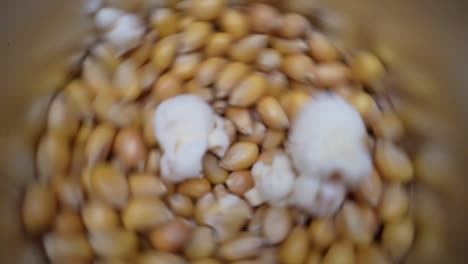 máquina giratoria de palomitas de maíz que produce palomitas de maíz amarillo, de arriba a abajo