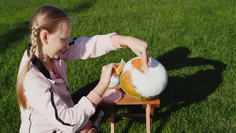 A-girl-of-10-years-old-paints-pumpkins,-prepares-jewelry-for-Helloween