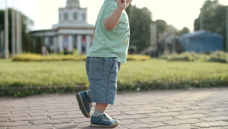 niño pequeño lindo caminando rápidamente al aire libre