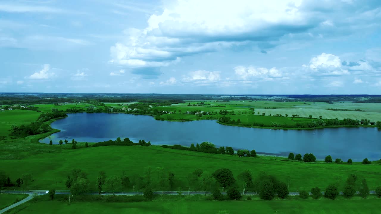 호수 위의 항공 영상, 풀밭 근처의 아름다운 날 nad 도로 nad 연못, 높은 나무와 구름이 있는 하늘