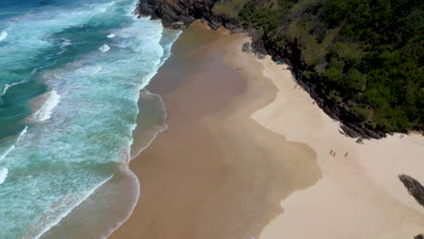 Inclinando-Hacia-Arriba-La-Toma-Cinematográfica-De-Un-Dron-Del-Océano-Y-La-Isla-En-La-Playa-Broken-Head-En-Australia