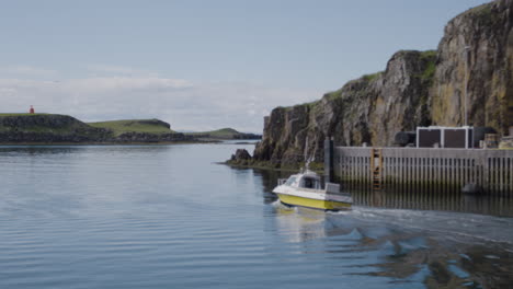 pequeño barco blanco y amarillo navegando a través de stykkisholmur en islandia