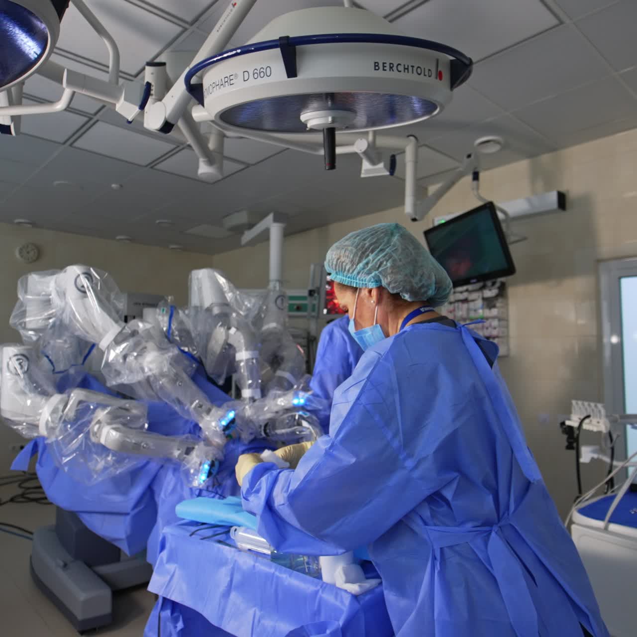 Modern up-to-date surgery room with robotic surgery equipment. Da Vinci robot performs surgery in the middle of the room assisted by human doctors
