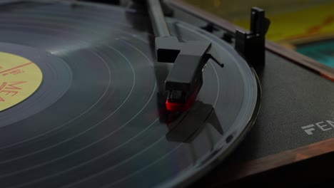 vinyl record spins on modern turntable with needle lowered for smooth audio playback, slow motion