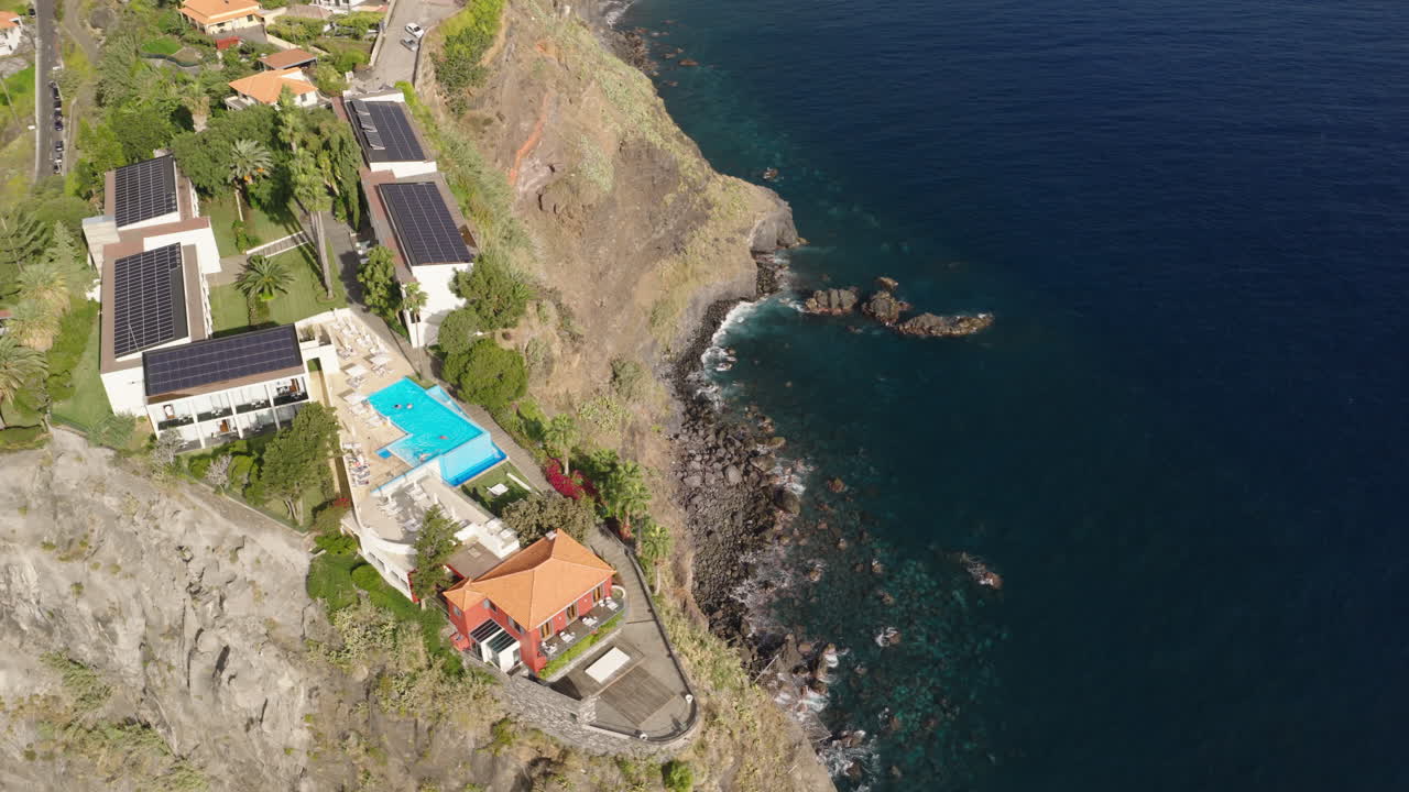 Vista Aérea de um Resort de Luxo na Falésia com Piscina e Oceano.