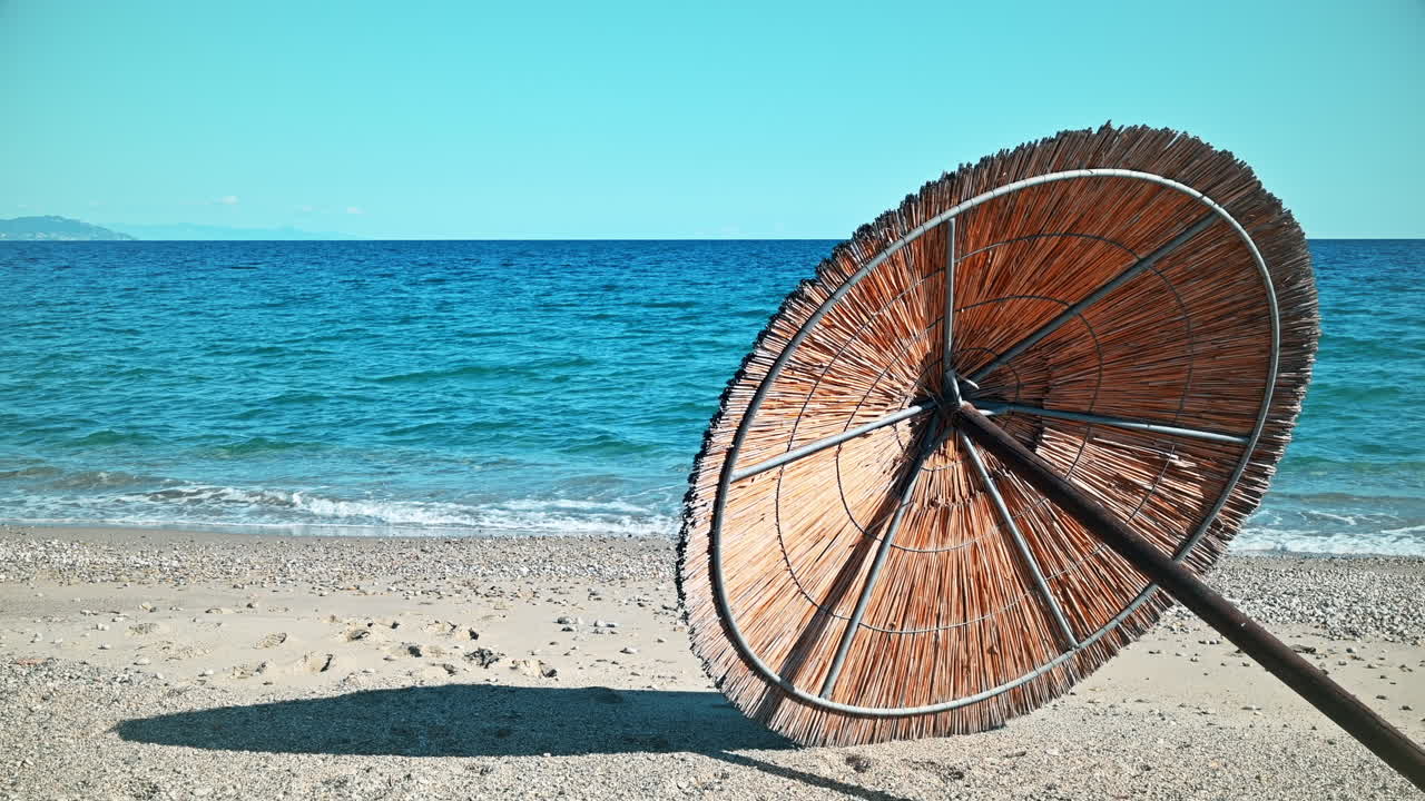 Beach umbrella lying on the Aegean sea coast in Asprovalta, Greece