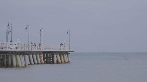 historical bridge over redlowo beach with people strolling in gdynia, poland