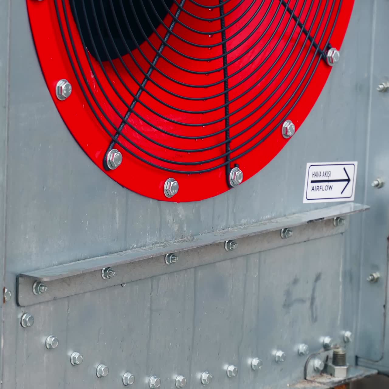 Big red ventilator at the granary tank. Fan for drying grain at the large agricultural plant during crops processing. Close up