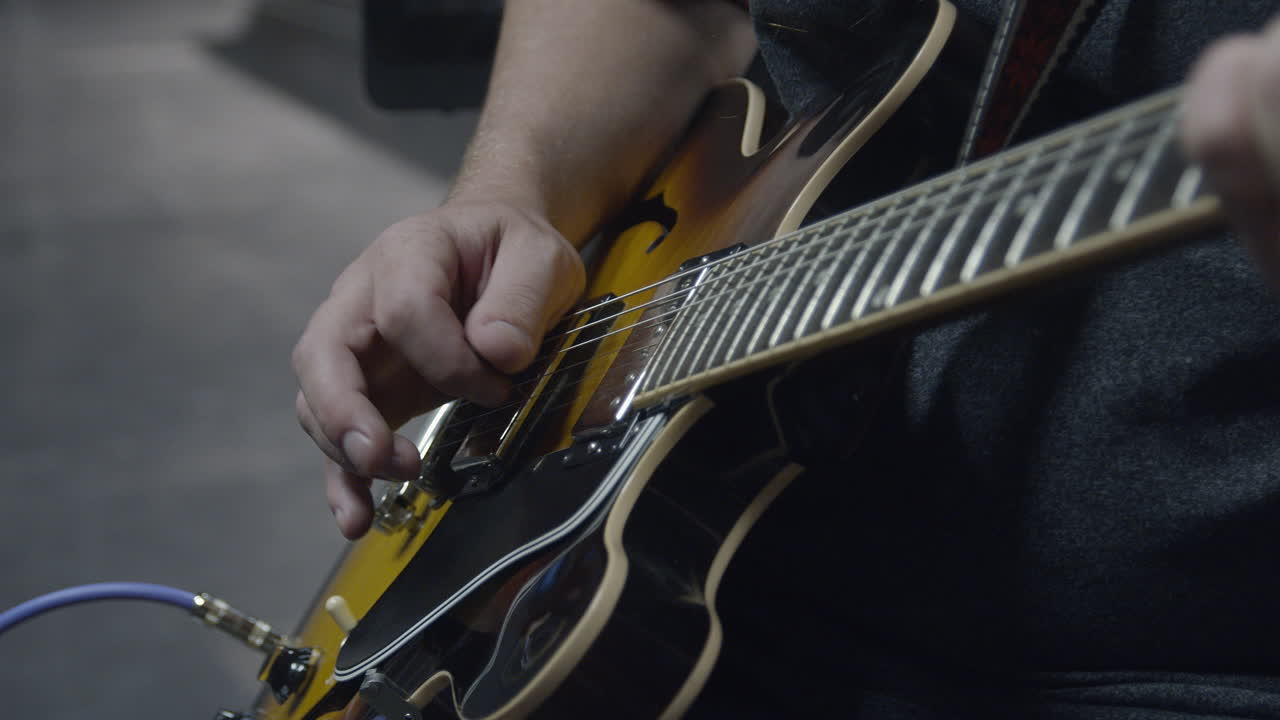 Closeup Slow Motion shot of guitar being played by musician on stage