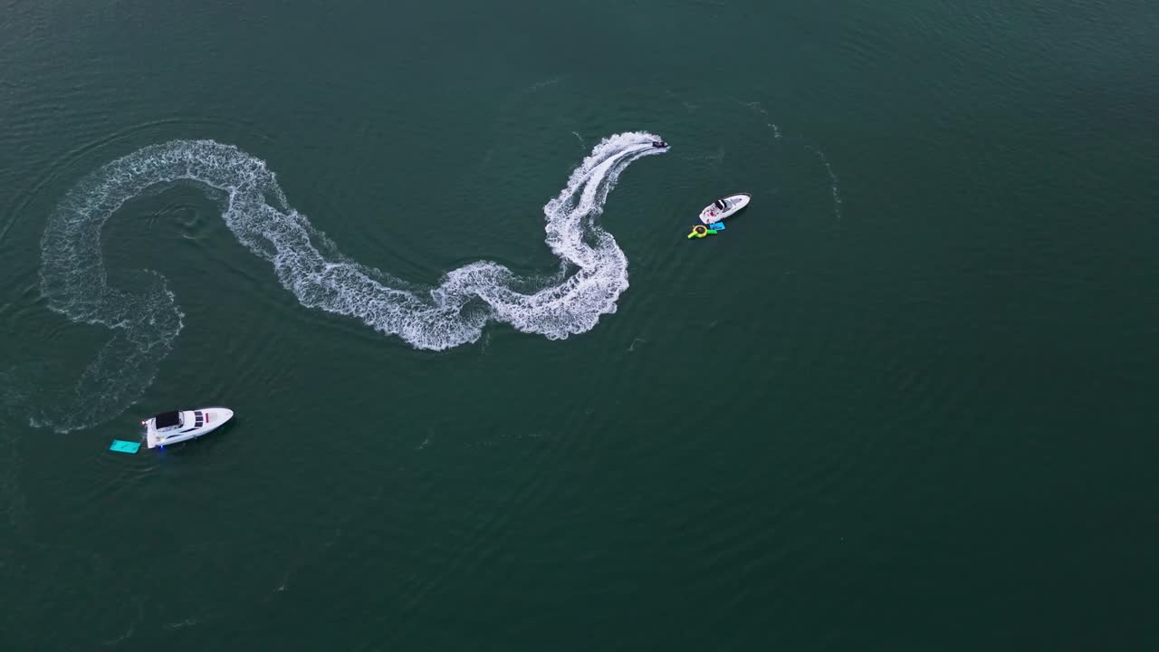 Drone shot of a jet ski doing circles in blue water of Biscayne Bay, Miami
