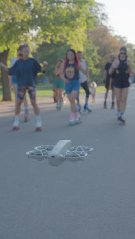 Vertical shot of drone hover while group of teenagers jam skate, Czechia