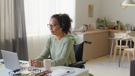 woman in wheelchair web conferencing at home