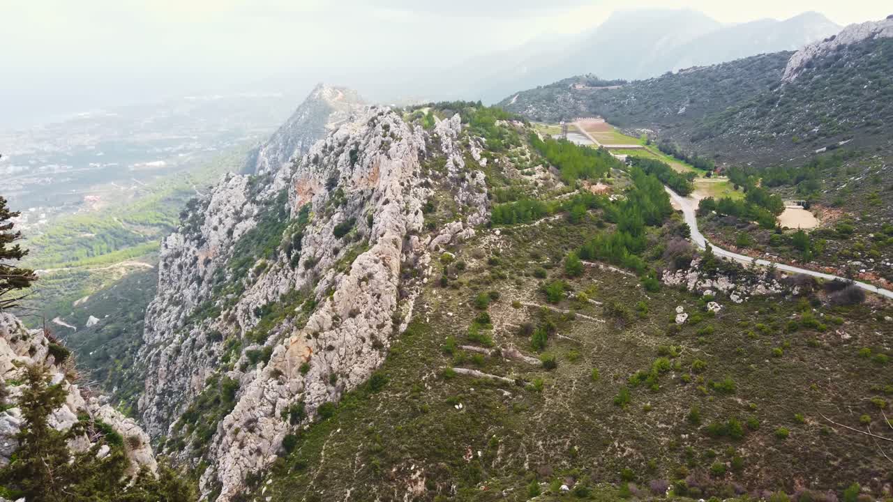 Green mountains range view from the ruins in Saint Hilarion Castle. Panoramic shot at sunlight. Fog in background. Slow motion. Kyrenia, Cyprus