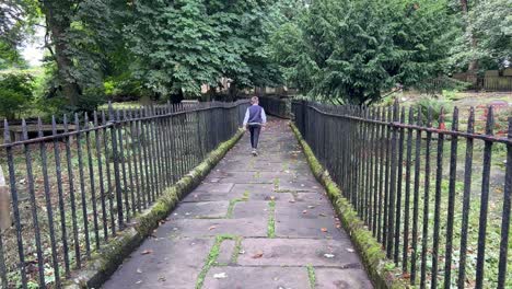 young boy walking through the graveyard at st michael and all angels church graveyard, haworth, final resting place of the bronte family
