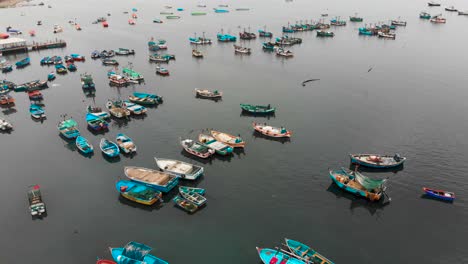 Orbital-shot-of-the-Marina-at-Paracas-town,-many-fishing-boats-parking-around